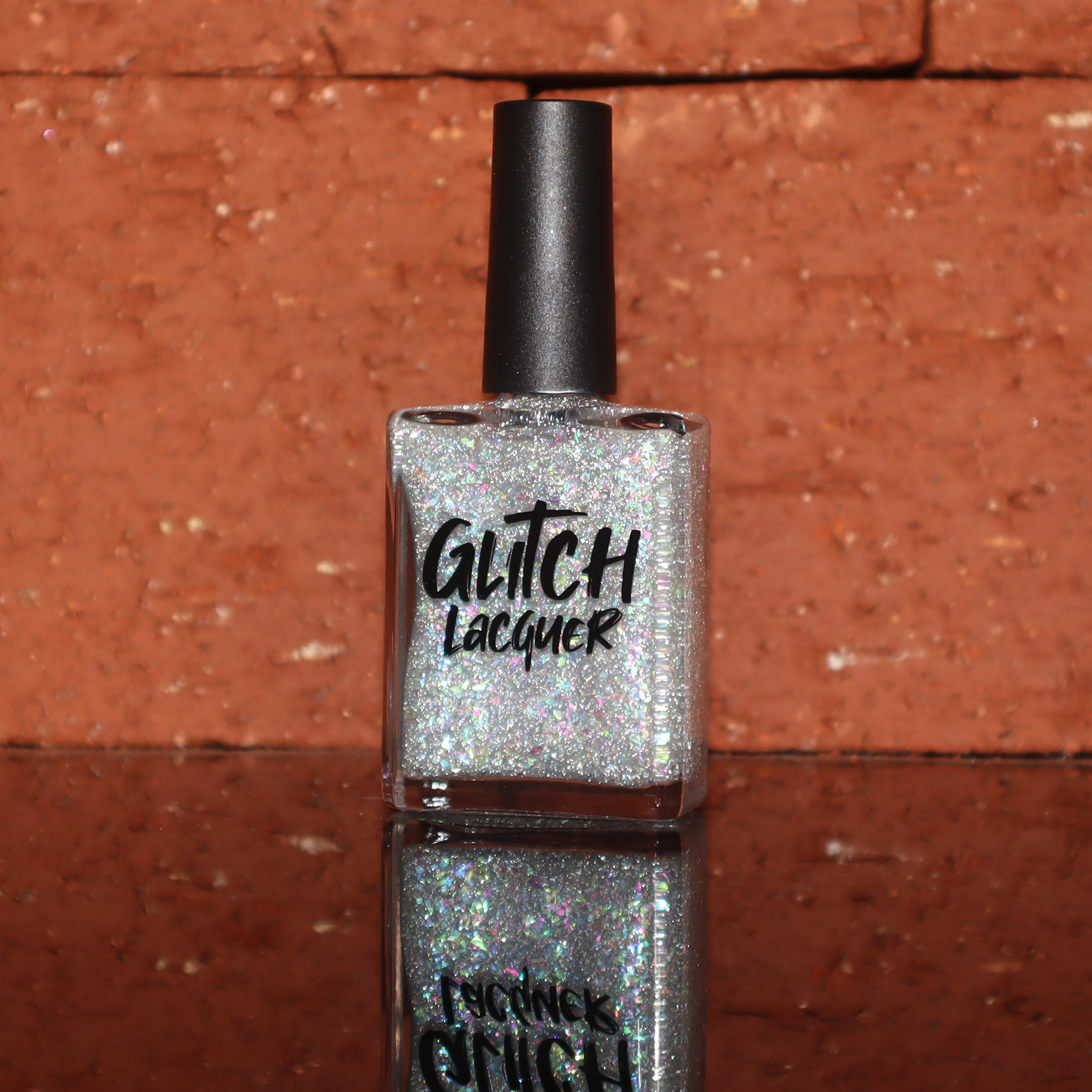 Be Gay, Do Crime by Glitch Lacquer, silver holographic reflective glitter and rainbow flake topper, bottle