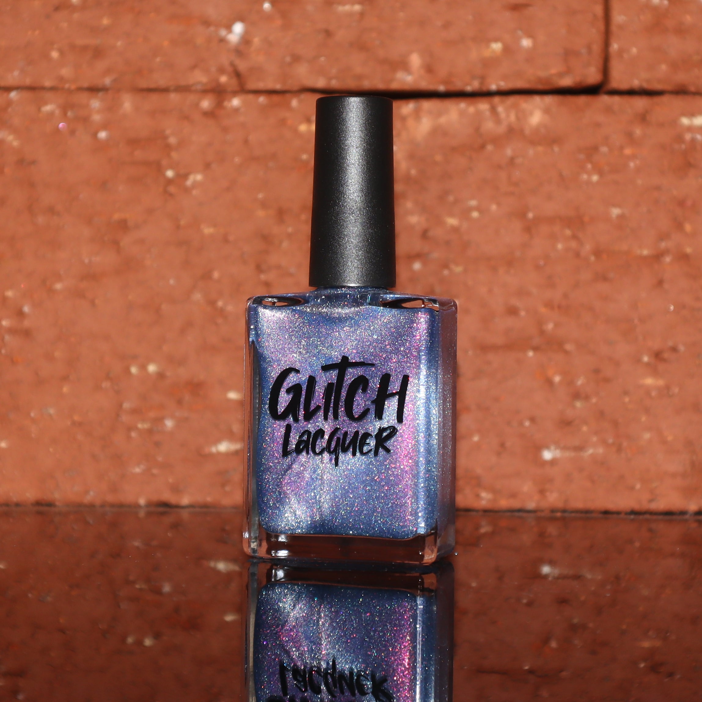 Protect the Dolls by Glitch Lacquer, blue jelly with pink-orange-green shimmer and silver magnetic, bottle
