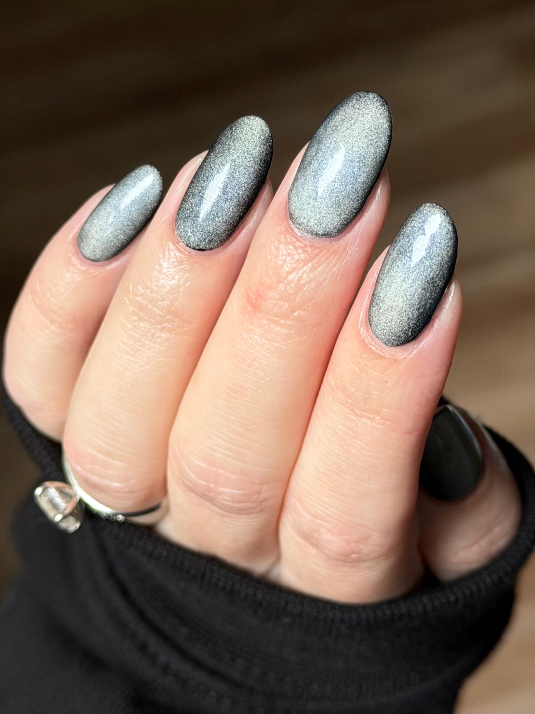 Ally by Glitch Lacquer, silver holographic magnetic topper, cat-eye effect, on light skin tone almond nails