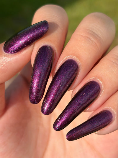 Sister Outsider by Glitch Lacquer, blackened purple jelly with magenta-purple sparkle, on light skin tone stiletto nails