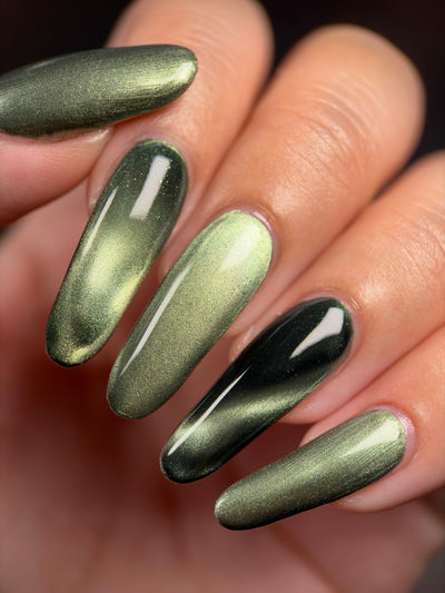 AUREA by Glitch Lacquer, blackened green base, greenish-gold magnetic cat-eye, on light-medium skin tone almond nails