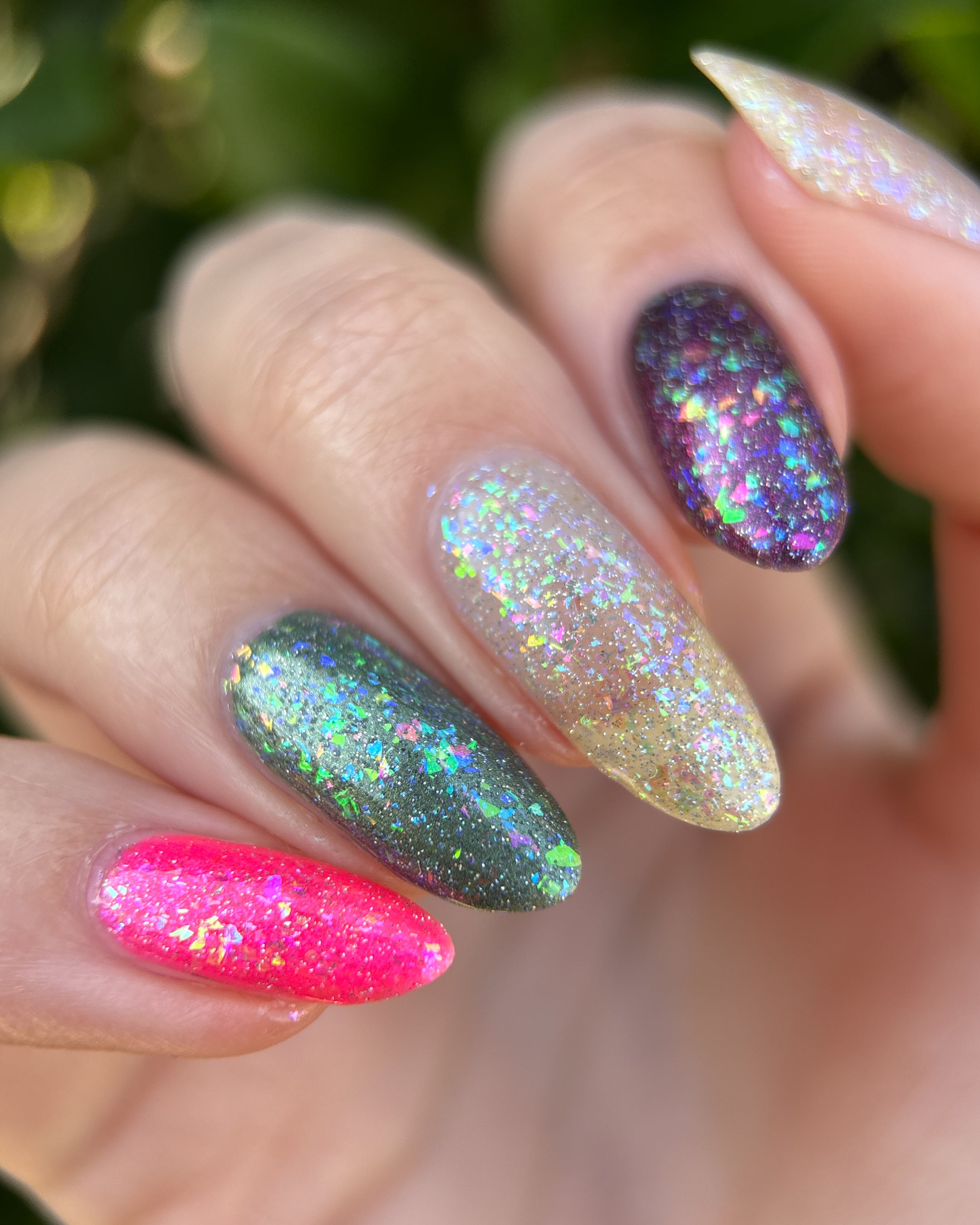 Be Gay, Do Crime by Glitch Lacquer, holo glitter and rainbow flake topper layered over four base colors, on light skin tone nails