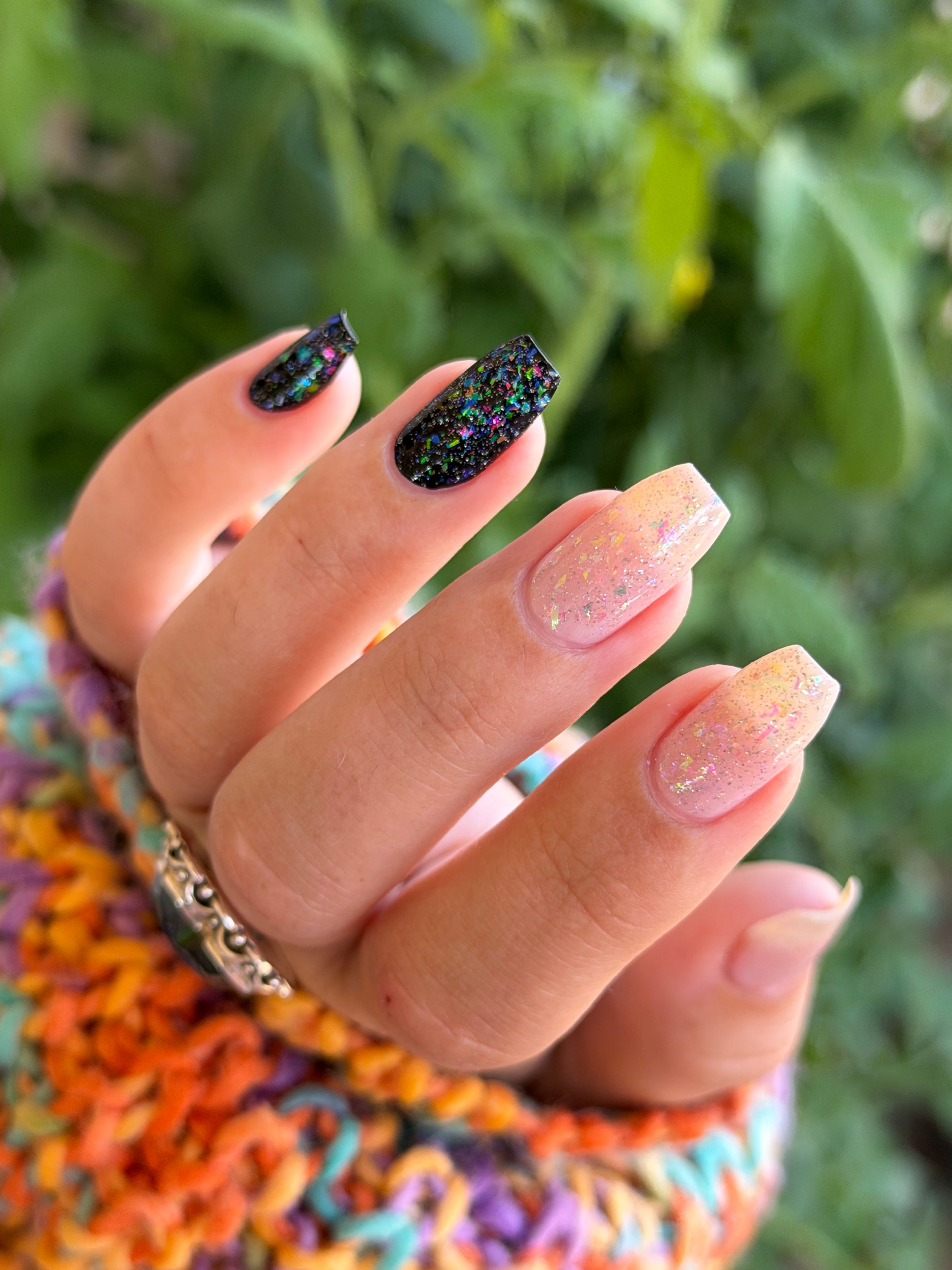 Be Gay, Do Crime by Glitch Lacquer, rainbow flake and holo glitter topper over black and nude bases, on light-medium skin tone nails