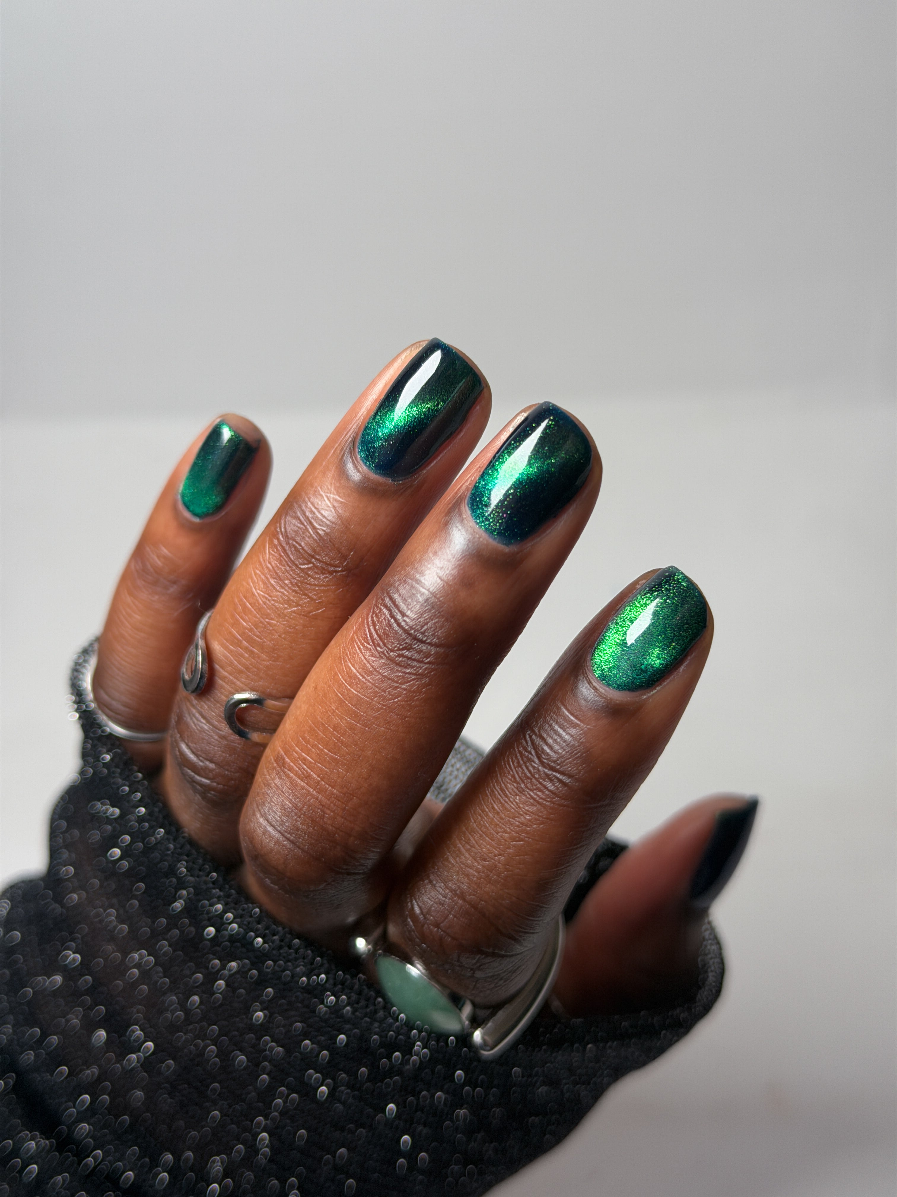 Do-Nuts by Glitch Lacquer, deep blue jelly, green-to-teal magnetic cat-eye, on deep skin tone square nails