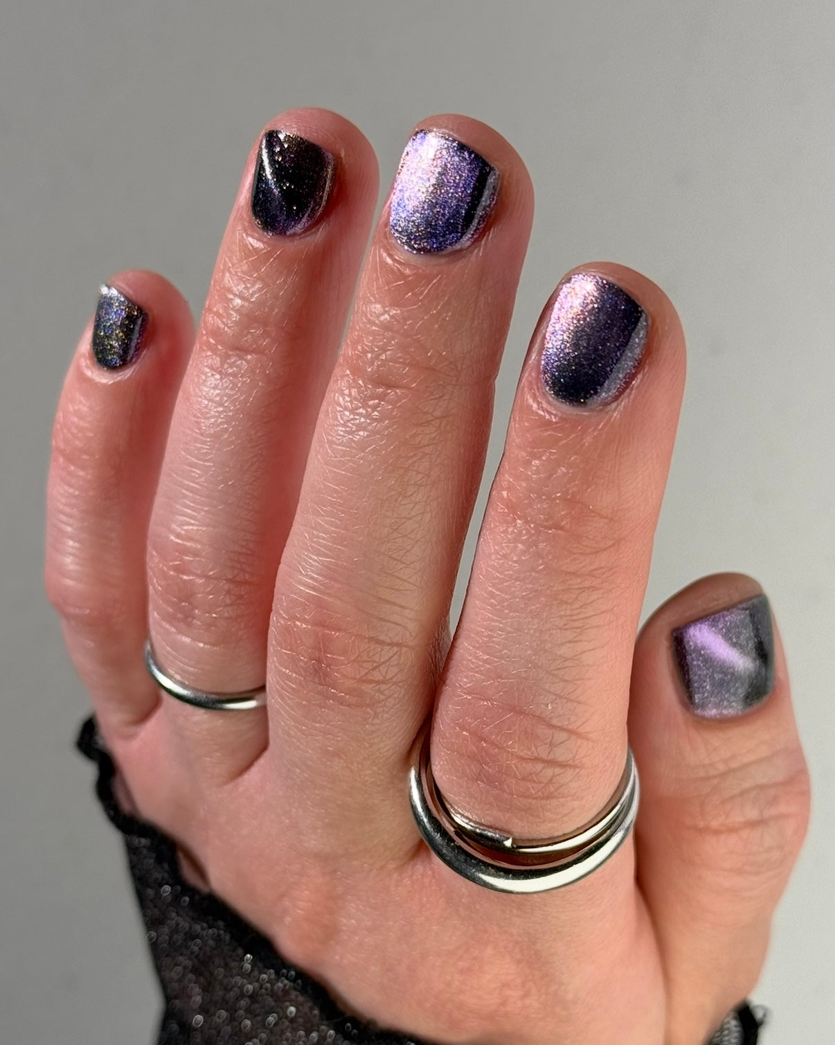 Lavender Menace by Glitch Lacquer, black jelly, purple-blue magnetic cat-eye, purple sparkle, on light skin tone square nails