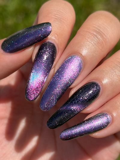 Lavender Menace by Glitch Lacquer, black jelly, purple sparkle, purple-to-blue magnetic, on light-medium skin tone almond nails