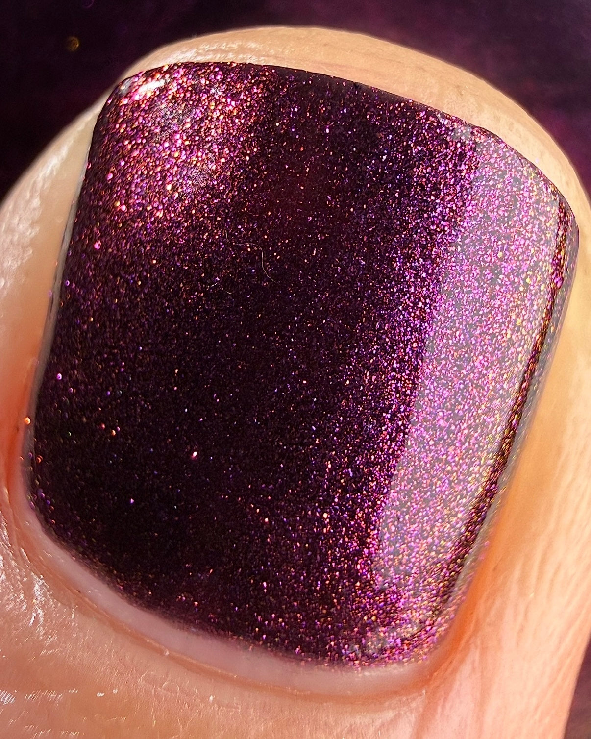 Sister Outsider by Glitch Lacquer, blackened purple jelly with magenta-purple sparkle, macro detail on light skin tone