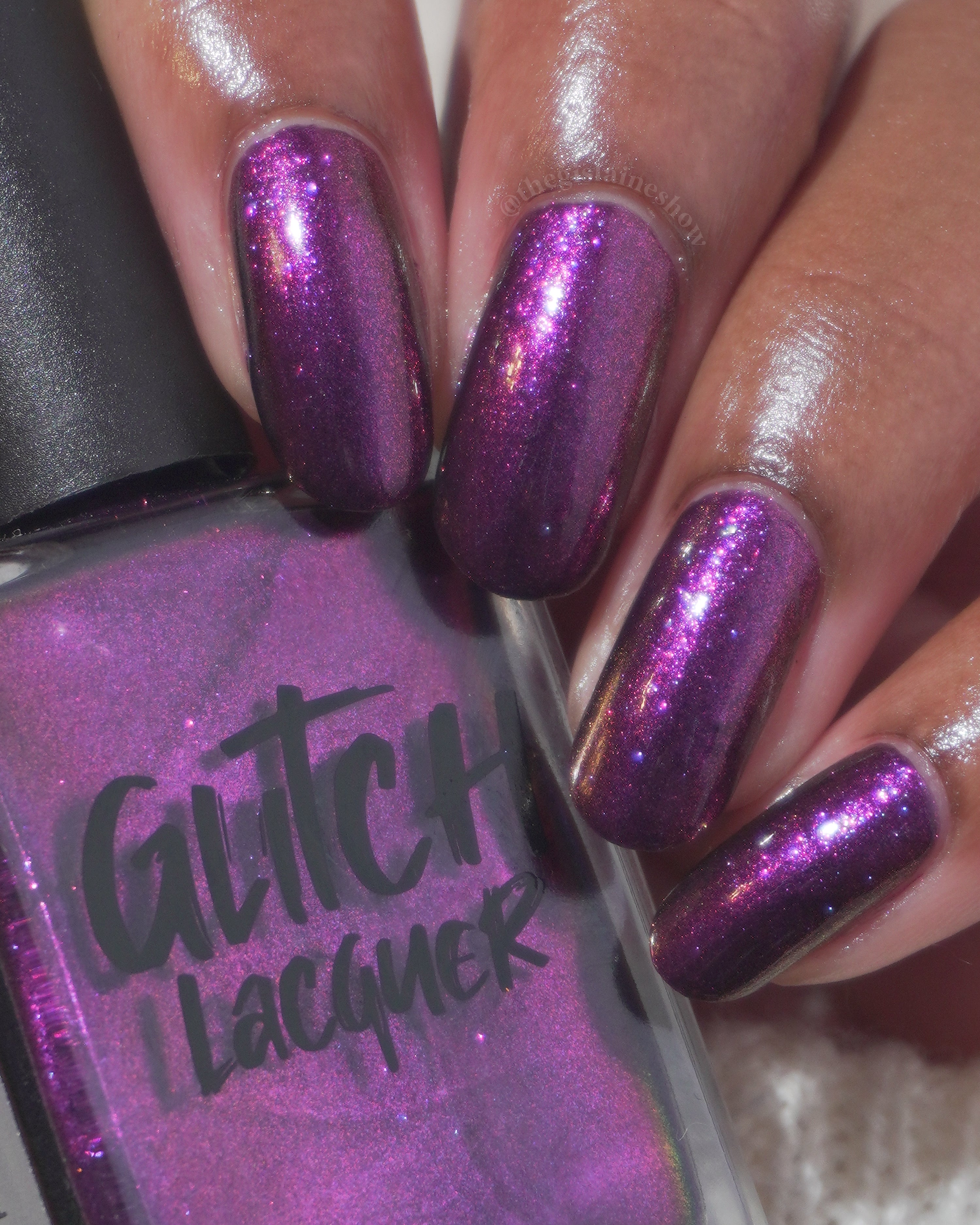 Sister Outsider by Glitch Lacquer, blackened purple jelly with magenta-purple sparkle, bottle and swatch on medium skin tone
